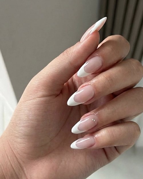 Mano con french bianca a mandorla e piccolo strass